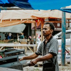 Young man looking at camera at market