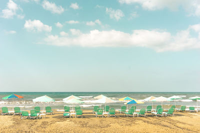 Beach umbrellas by sea against sky