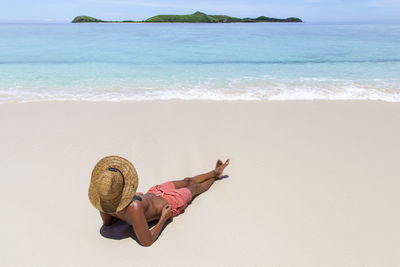 Man lying on sand at beach