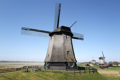 Traditional windmill on field against sky