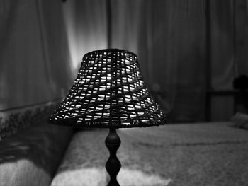Close-up of illuminated lamp against wall at home