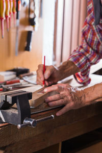 Midsection of carpenter working at workshop