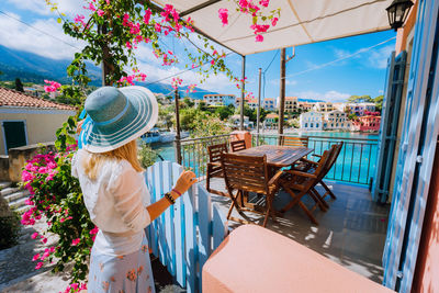 Rear view of woman in restaurant looking at sea