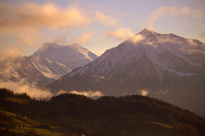 Scenic view of snowcapped mountains against sky during sunset