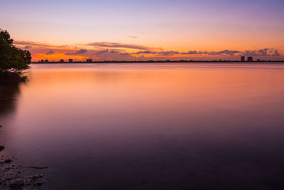 Scenic view of lake against romantic sky at sunset