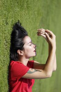 Side view of young woman standing in grass