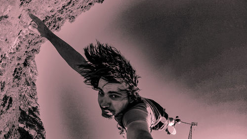 Low angle view of young man against sky