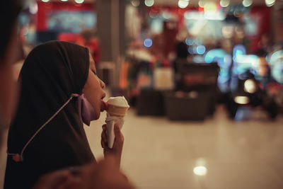 Young girl drinking ice cream at restaurant