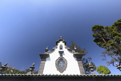 Low angle view of bell tower against blue sky