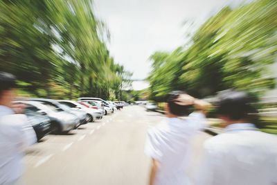 Blurred motion of woman on road against sky