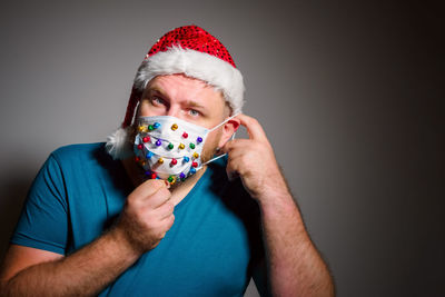 Adult man in christmas decorated mask at home because coronavirus. new normal, social distancing