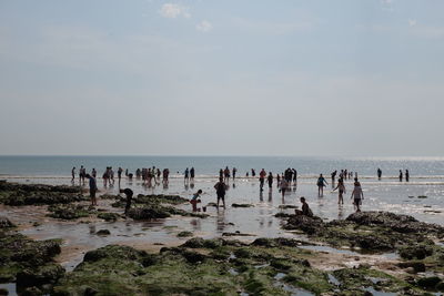 People on beach against sky