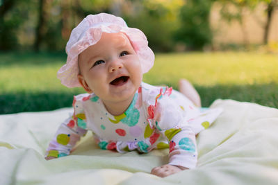 Portrait of cute baby girl lying on bed