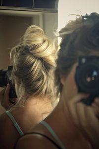 Close-up of woman photographing through camera at home