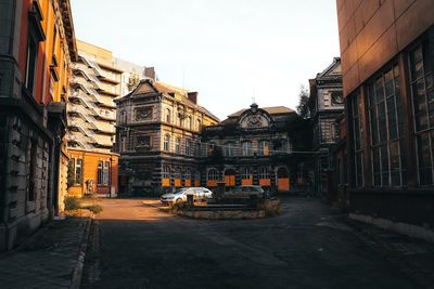 Cars on street amidst buildings in city against clear sky