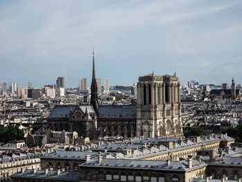 Buildings in city against cloudy sky