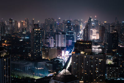 Illuminated cityscape against sky at night