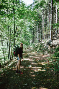 Rear view of woman walking on footpath in forest