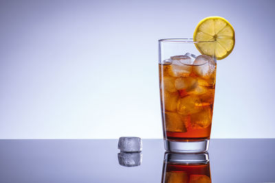 Close-up of drink against glass over white background