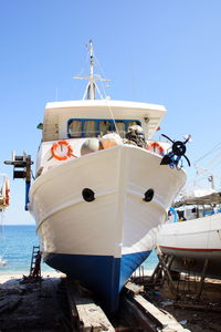 Ship moored at harbor against sky