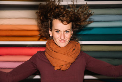 Joyful young woman with curly hair in a fabric store