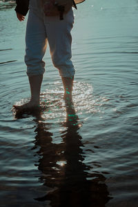 Low section of man standing in water