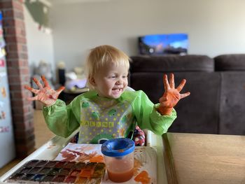 Portrait of baby girl  playing with paints, drawing baby watercolours 