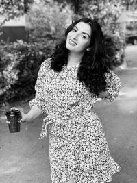 Portrait of smiling woman standing against wall