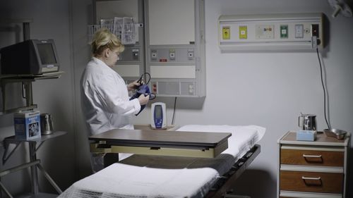 Midsection of woman using smart phone on table