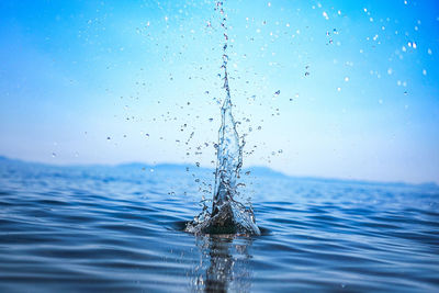 Close-up of water splashing against blue sky