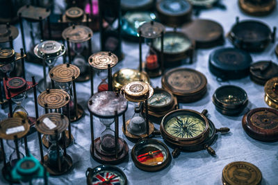 High angle view of navigational compasses and hourglass at market stall
