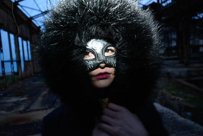 Portrait of young woman wearing mask in abandoned house