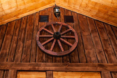 Low angle view of wheel on wooden wall