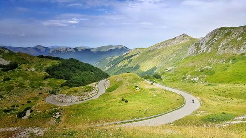 Scenic view of grassy field against cloudy sky
