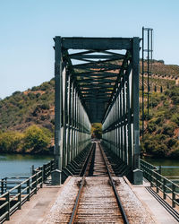 Footbridge over river against clear sky