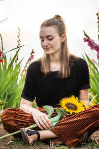 Beautiful young woman with pink flowers in basket