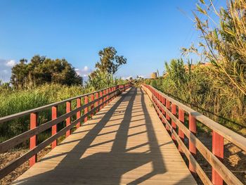 View of footbridge against clear blue sky