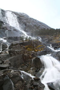 Scenic view of waterfall against sky