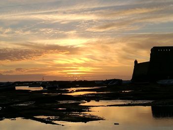 Silhouette of boats in sea during sunset