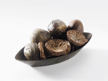 Close-up of dried food in bowl over white background