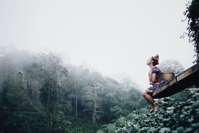 Woman on mountain road against sky