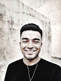 Portrait of smiling young man against wall