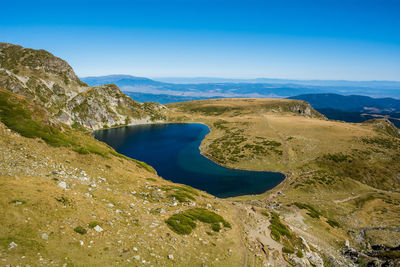 Scenic view of lake and mountains against blue sky