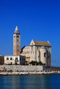 Building in front of river against clear blue sky