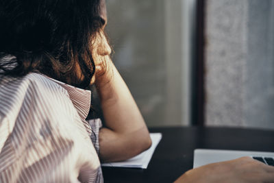 Rear view of woman sitting at home