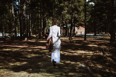 Rear view of woman walking on field