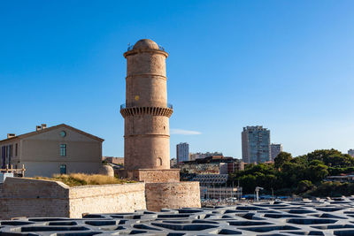 Low angle view of factory against clear blue sky