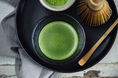 High angle view of cup of green tea on table