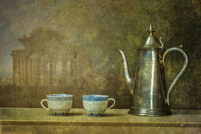 Close-up of wine glasses on table against wall