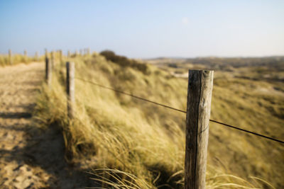 Close-up of barbed wire fence on field